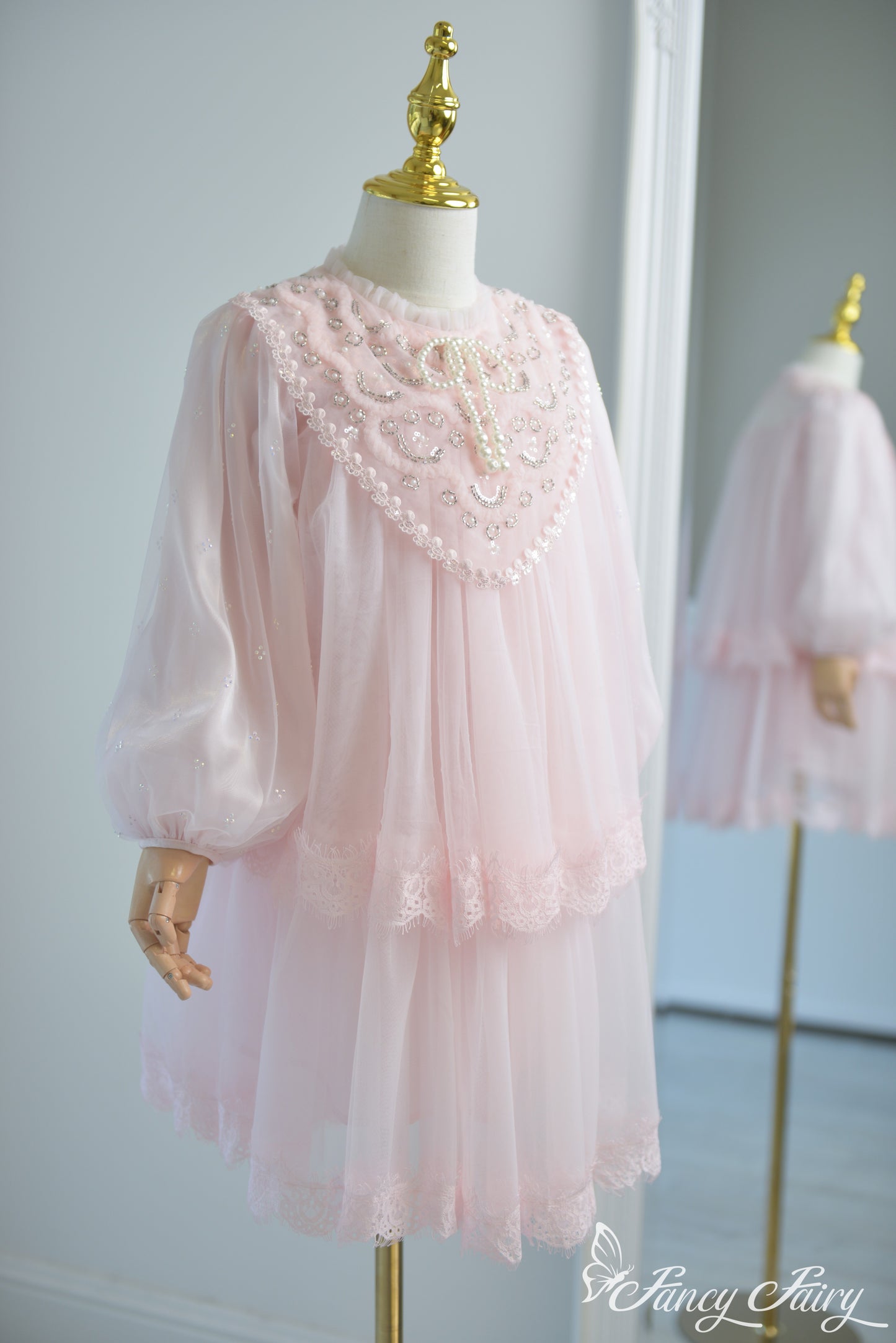 Side view of pink girls' lace dress with puff sleeves and pearl embroidery.
