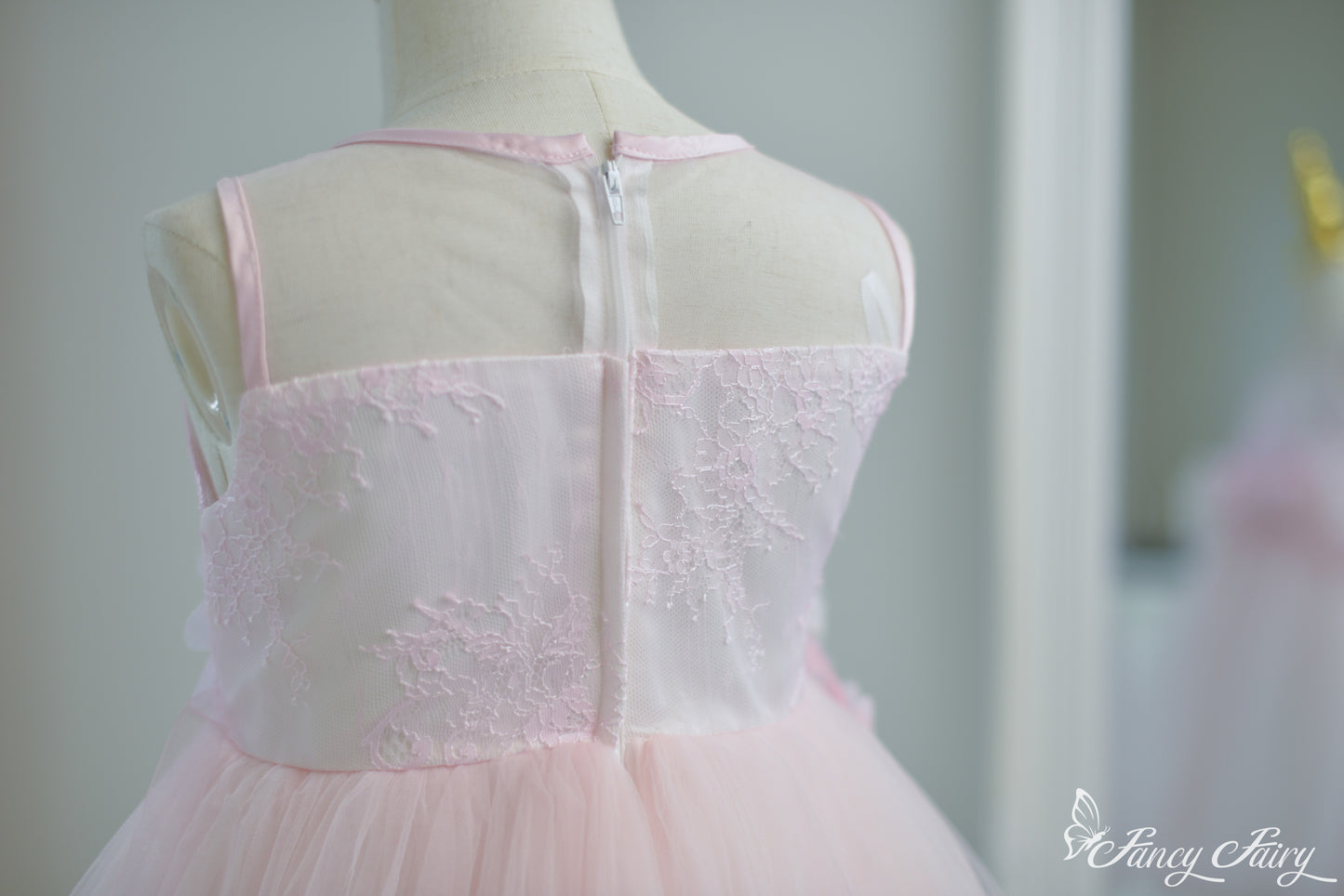 Back view showing zipper closure, sheer mesh neckline, and soft fit.