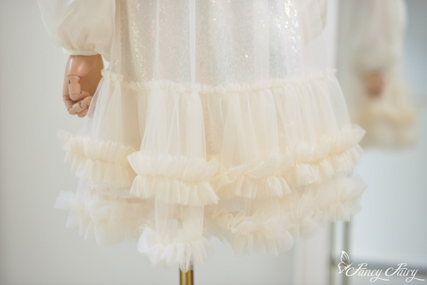 Zoom-in of ruffle layers and sequin sparkle on apricot mesh.