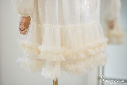 Zoom-in of ruffle layers and sequin sparkle on apricot mesh.