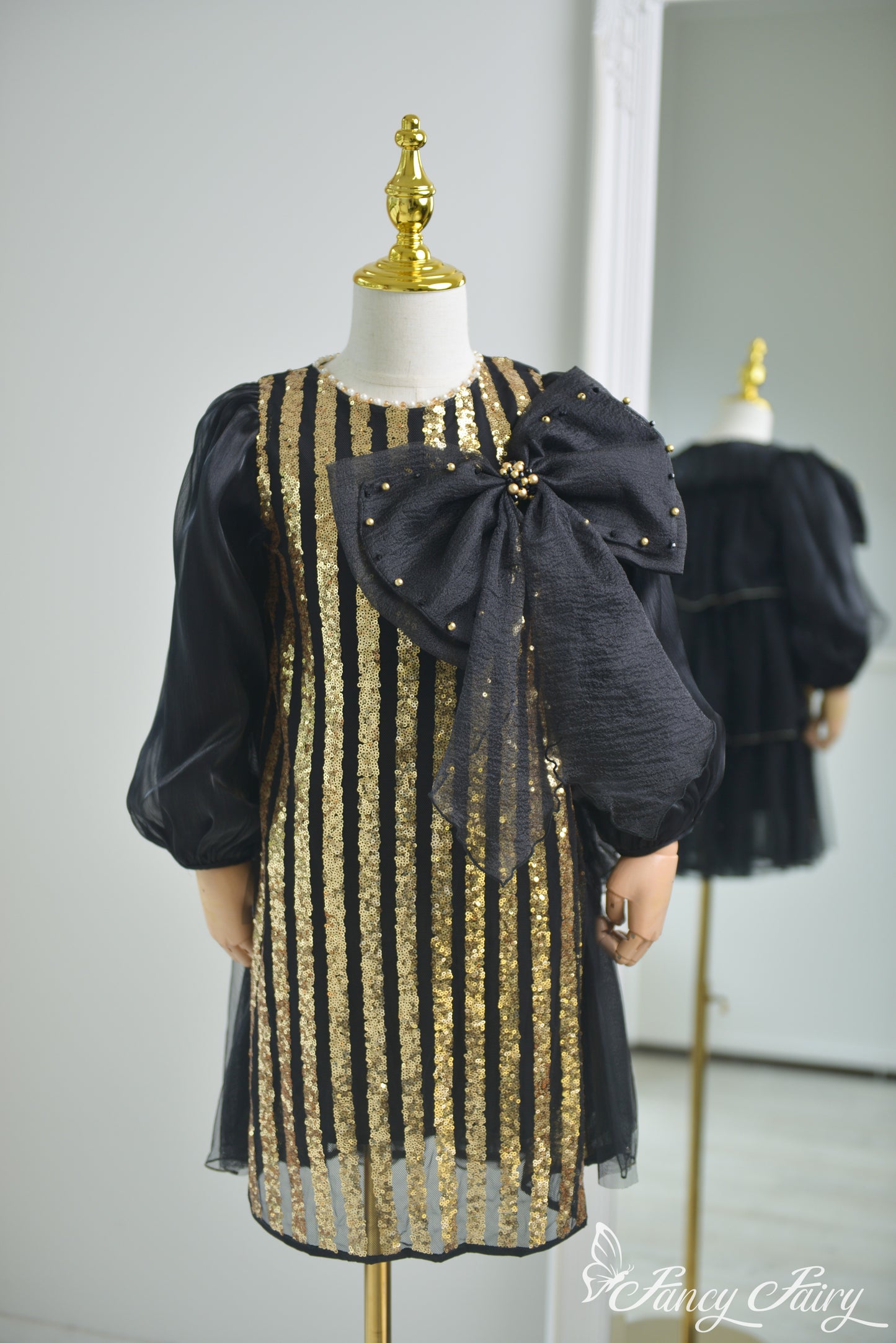 Front view of black and gold sequin dress with puff sleeves and bold black bow - Fancy Fairy