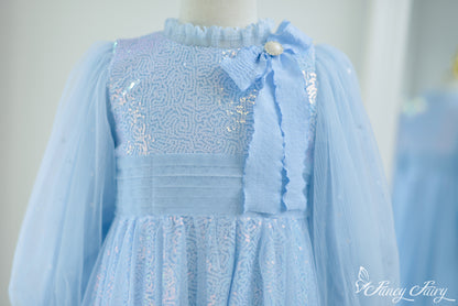 Close-up of glittery bodice with textured shimmer and soft blue ribbon bow.