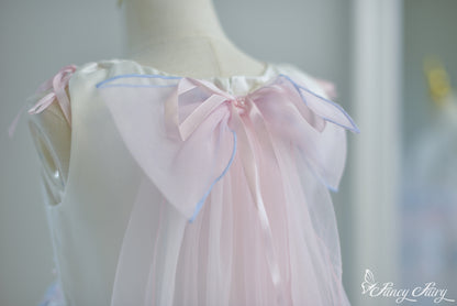 Close-up of back neckline and large detachable bow tied with pastel ribbon.