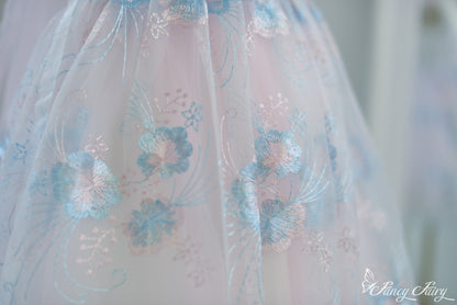 Close-up of skirt showing pastel blue floral patterns on sheer pink overlay.