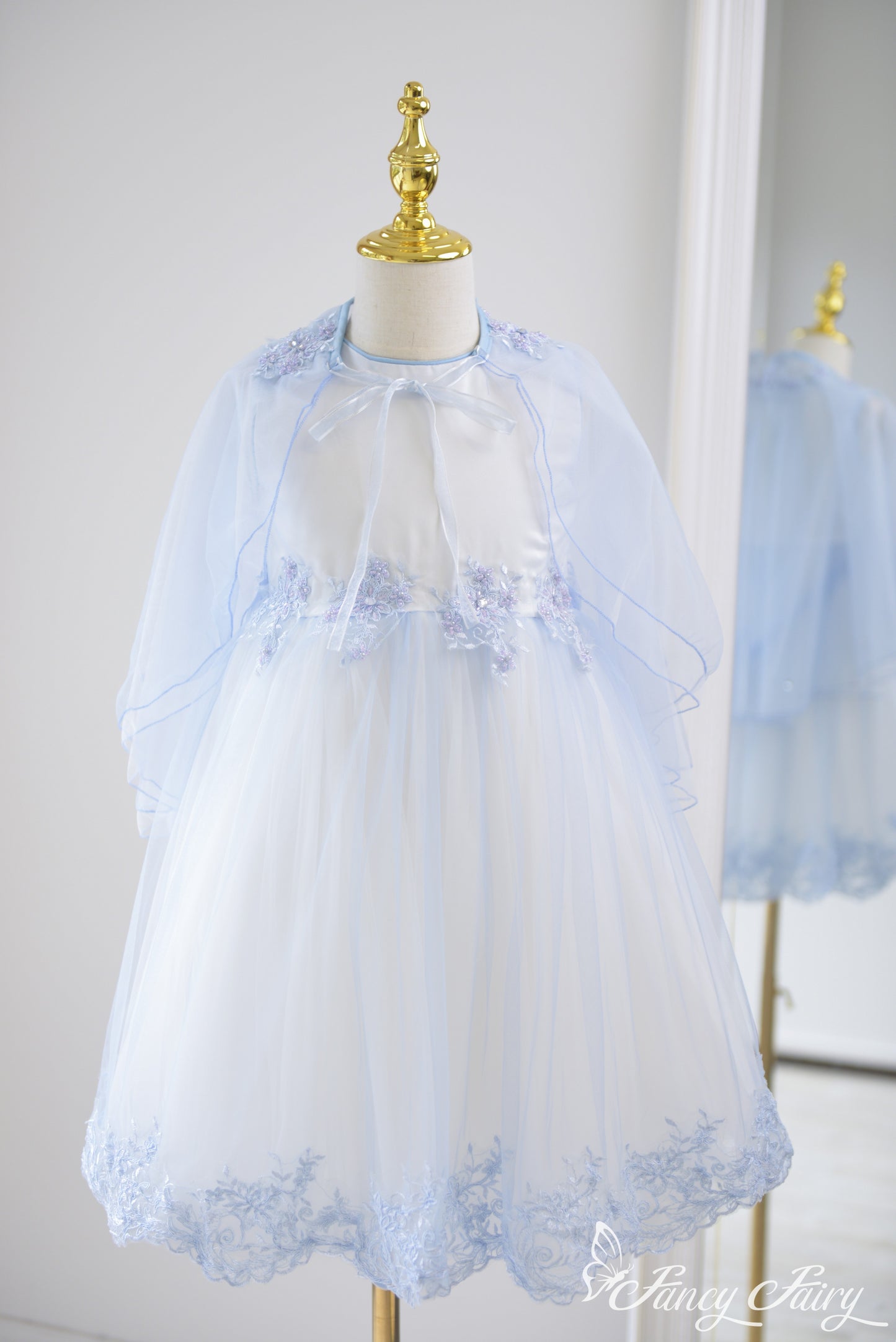 Front view of light blue A-line girls' dress with sheer cape and floral embroidery – Fancy Fairy