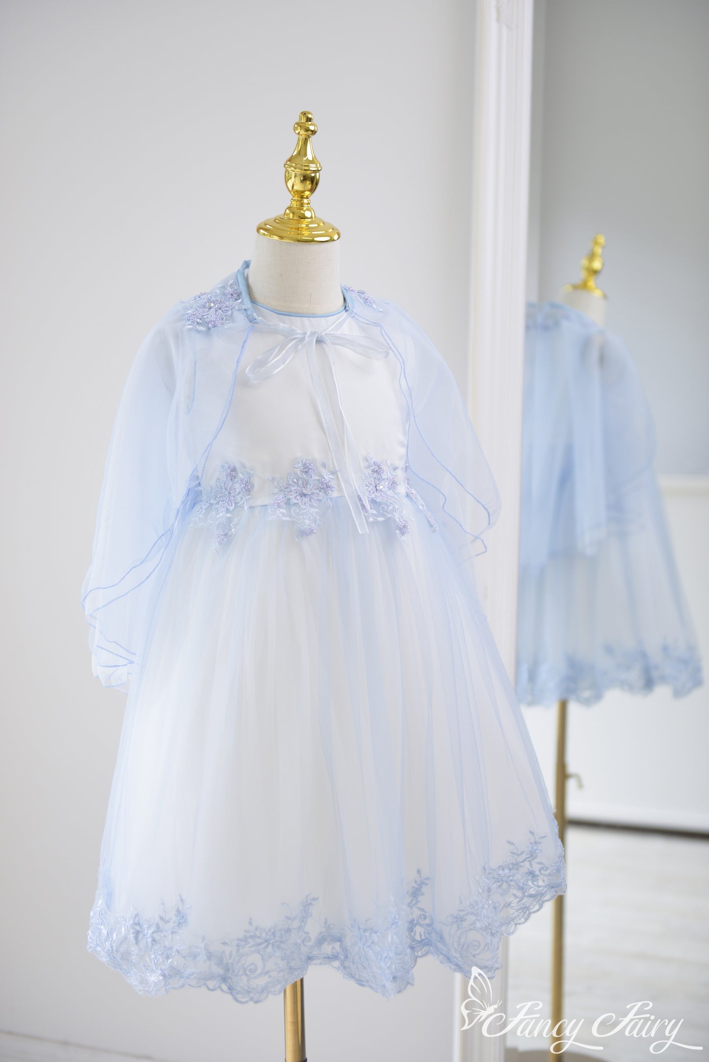 Full-length view of the dress from side angle, highlighting flowing cape.