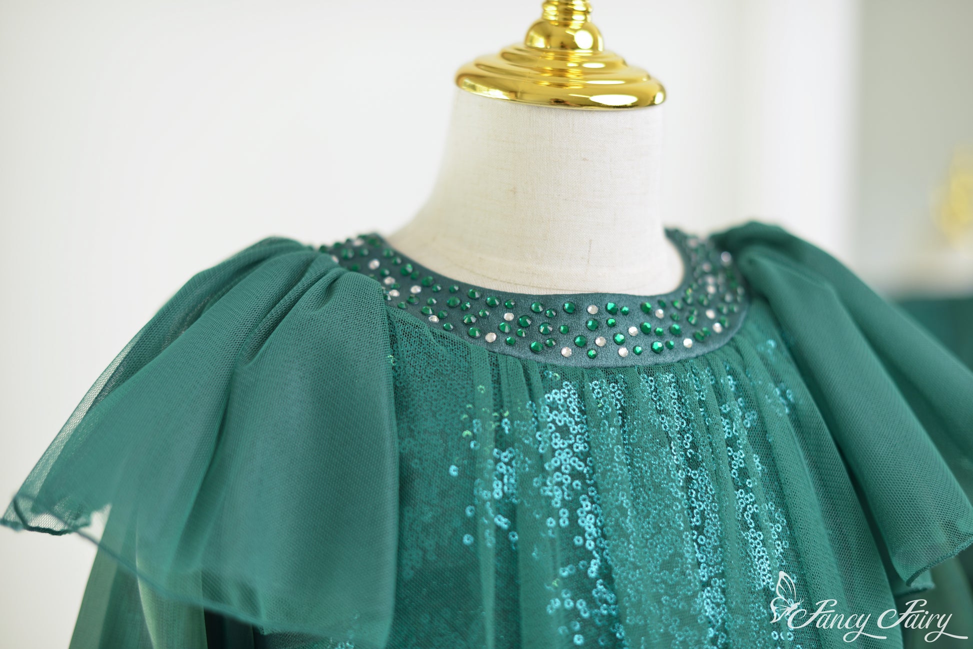 Shoulder angle of flutter sleeve and glistening mesh overlay.