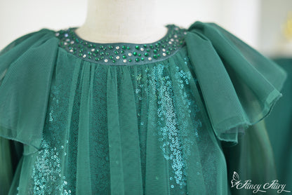 Close-up of beaded neckline with emerald rhinestones and layered mesh.