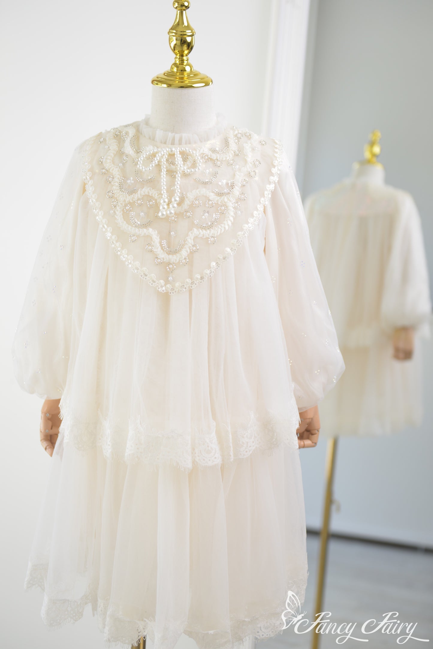 Front view of ivory girls' lace dress with puff sleeves and pearl embroidery.