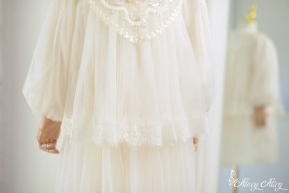 Detail of ivory lace dress puff sleeve and layered lace hem.