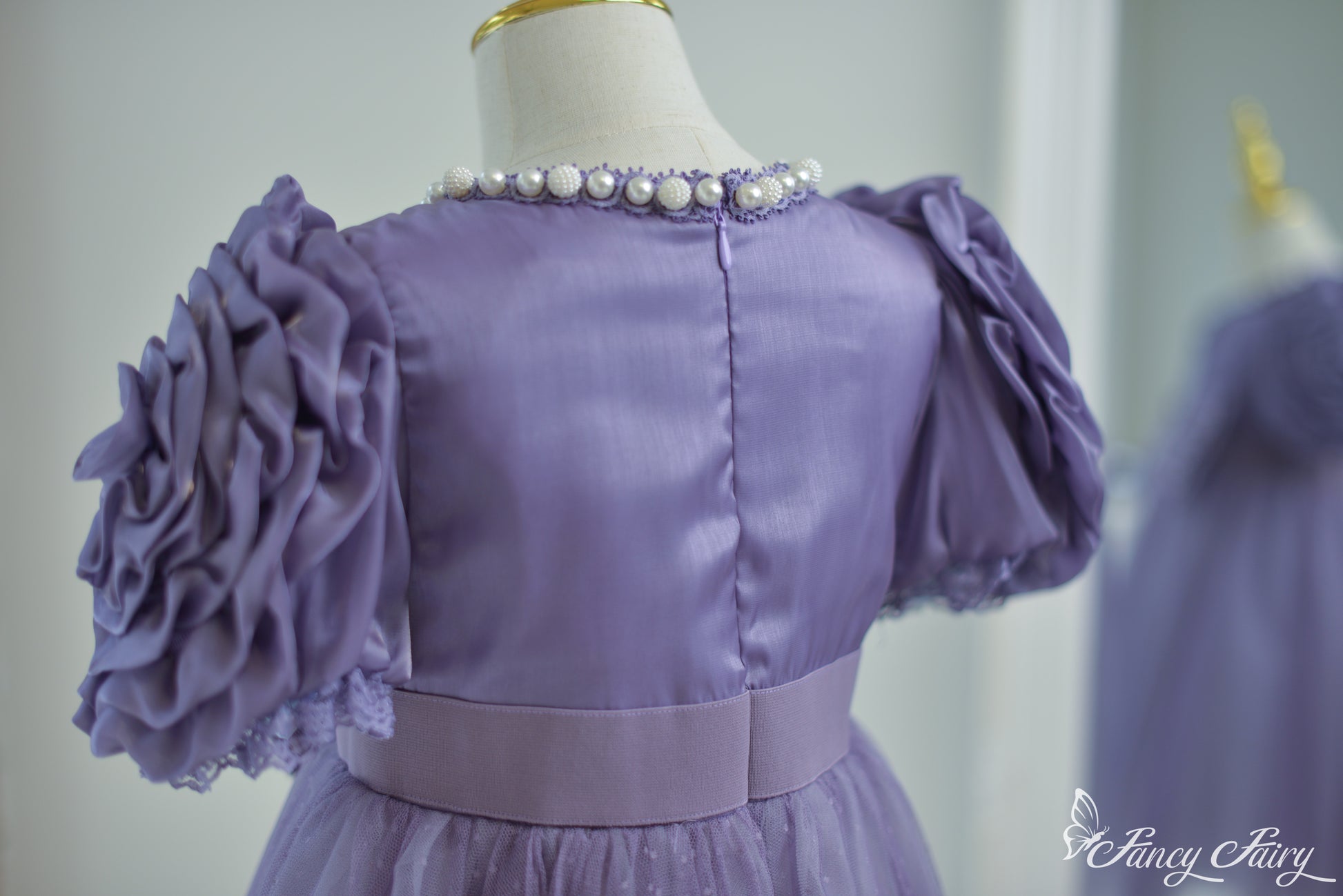 Back view showing zipper closure and gathered waist fit.