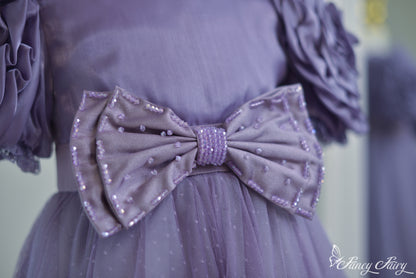 Close-up of oversized satin bow with sequin dots and lavender waistband.
