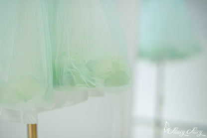 Close-up of mint tulle skirt showing floating petals within bottom hem.