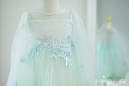 Front close-up of mint green girls' dress with floral embroidery, sheer sleeves and floral embroidery.