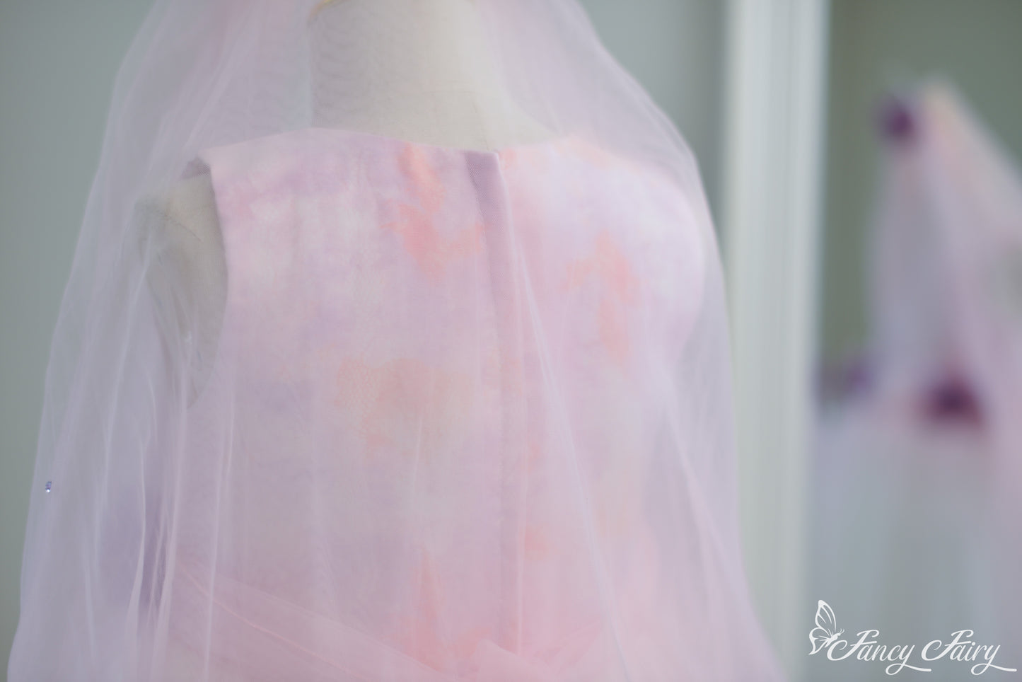 Back view showing zipper closure, and sheer tulle veil overlay.