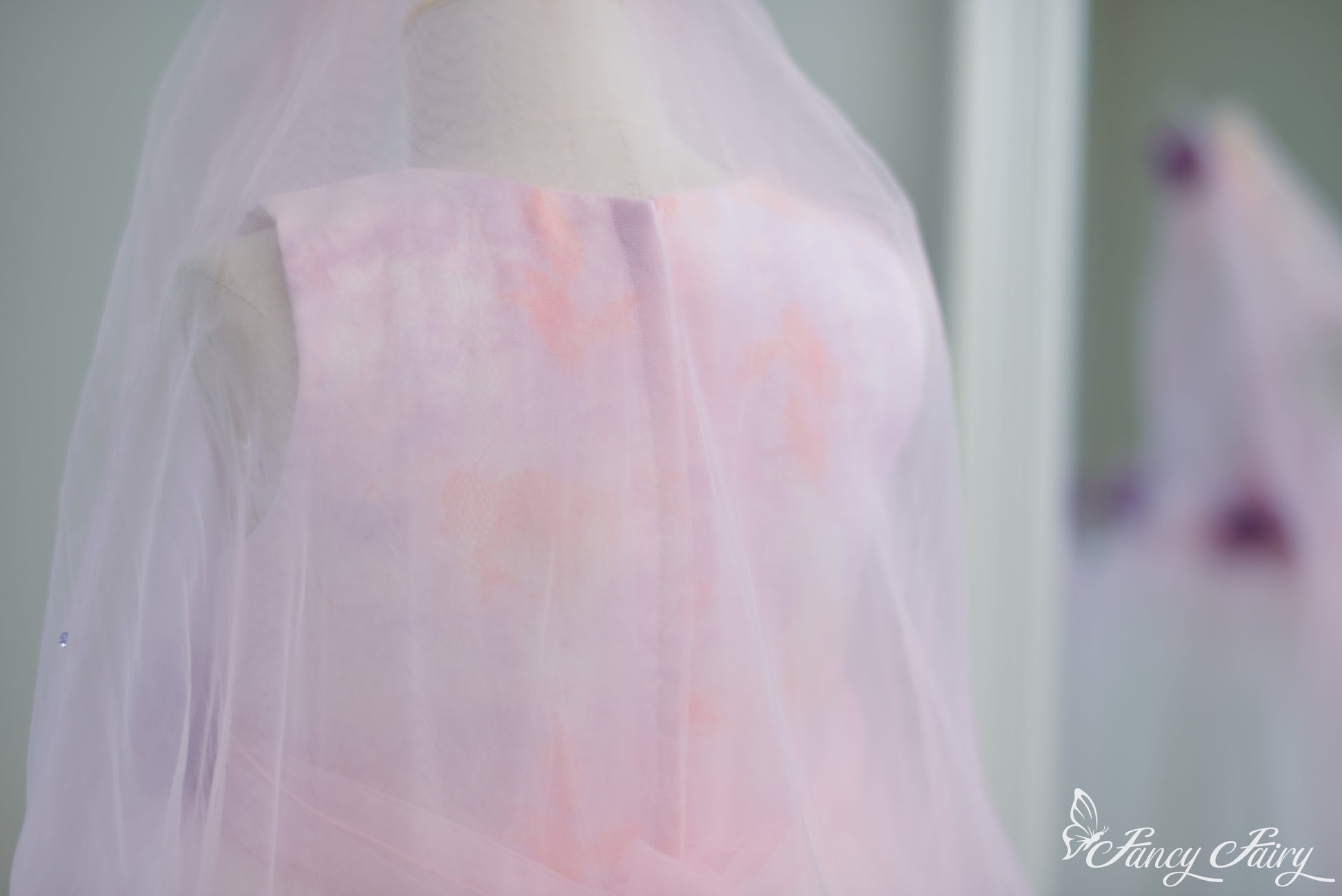 Back view showing zipper closure, and sheer tulle veil overlay.