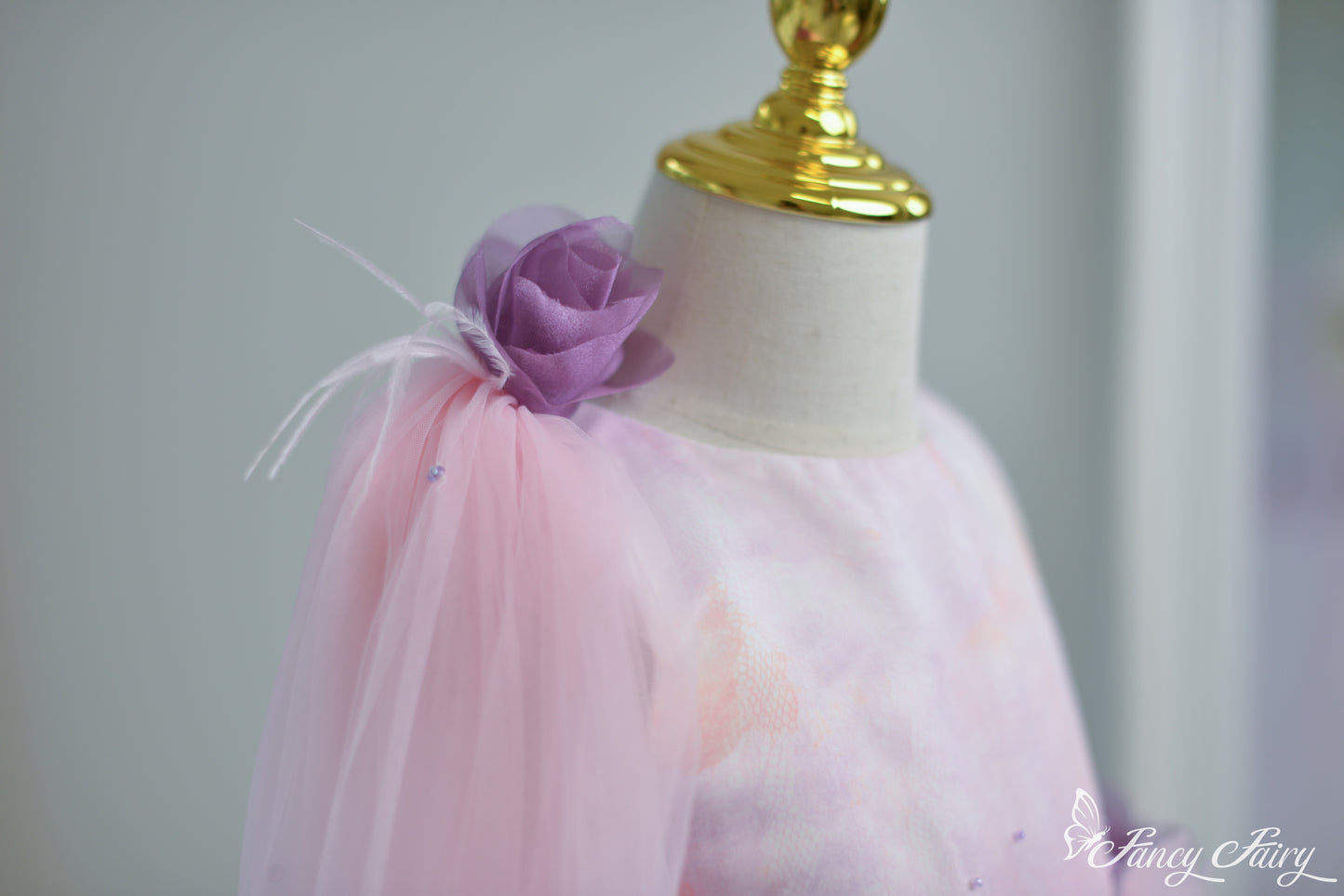 Side view of pink veil clipped on shoulder with flowing mesh overlay.