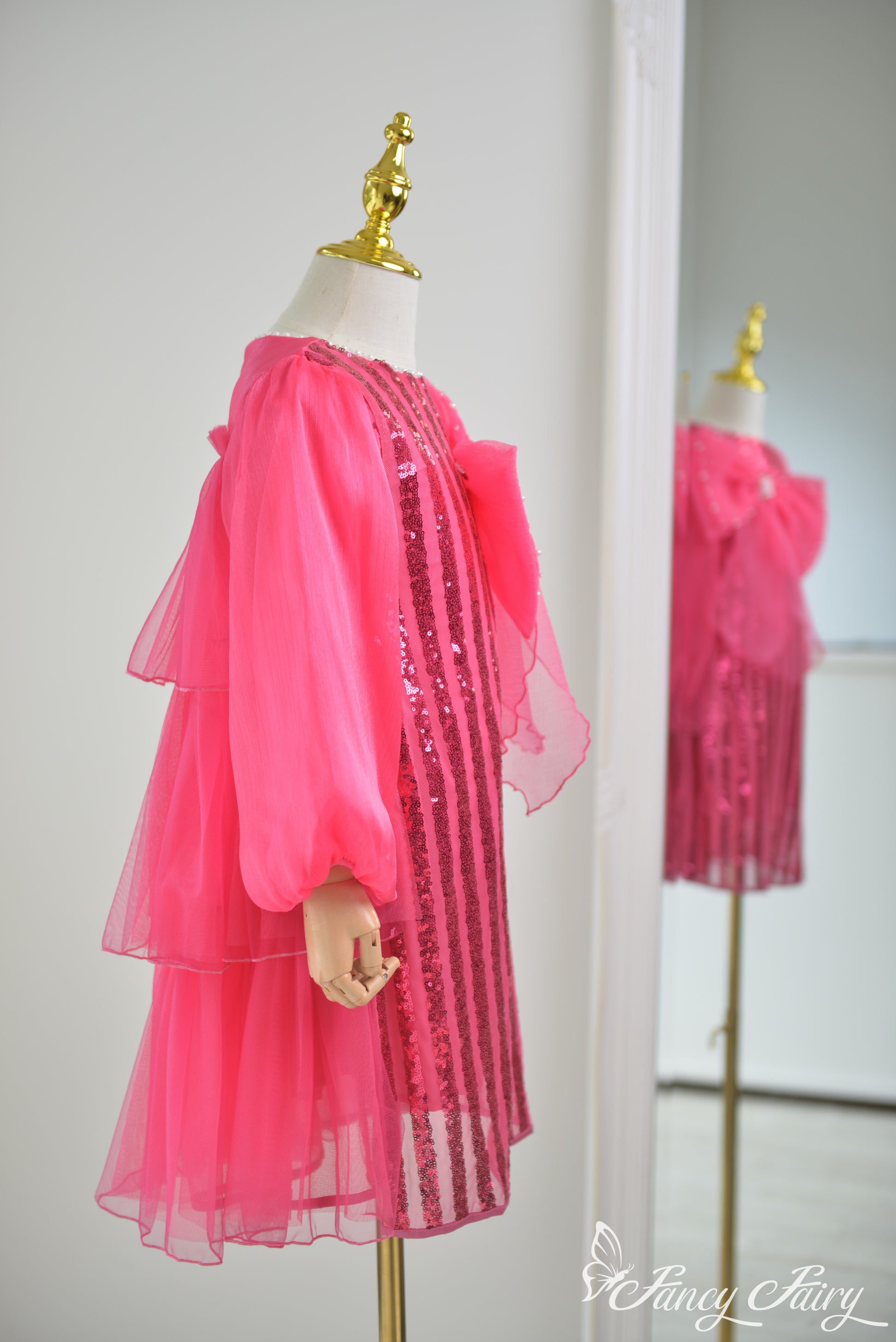 Side angle showing flow of hot pink tulle sleeves and back ruffles.