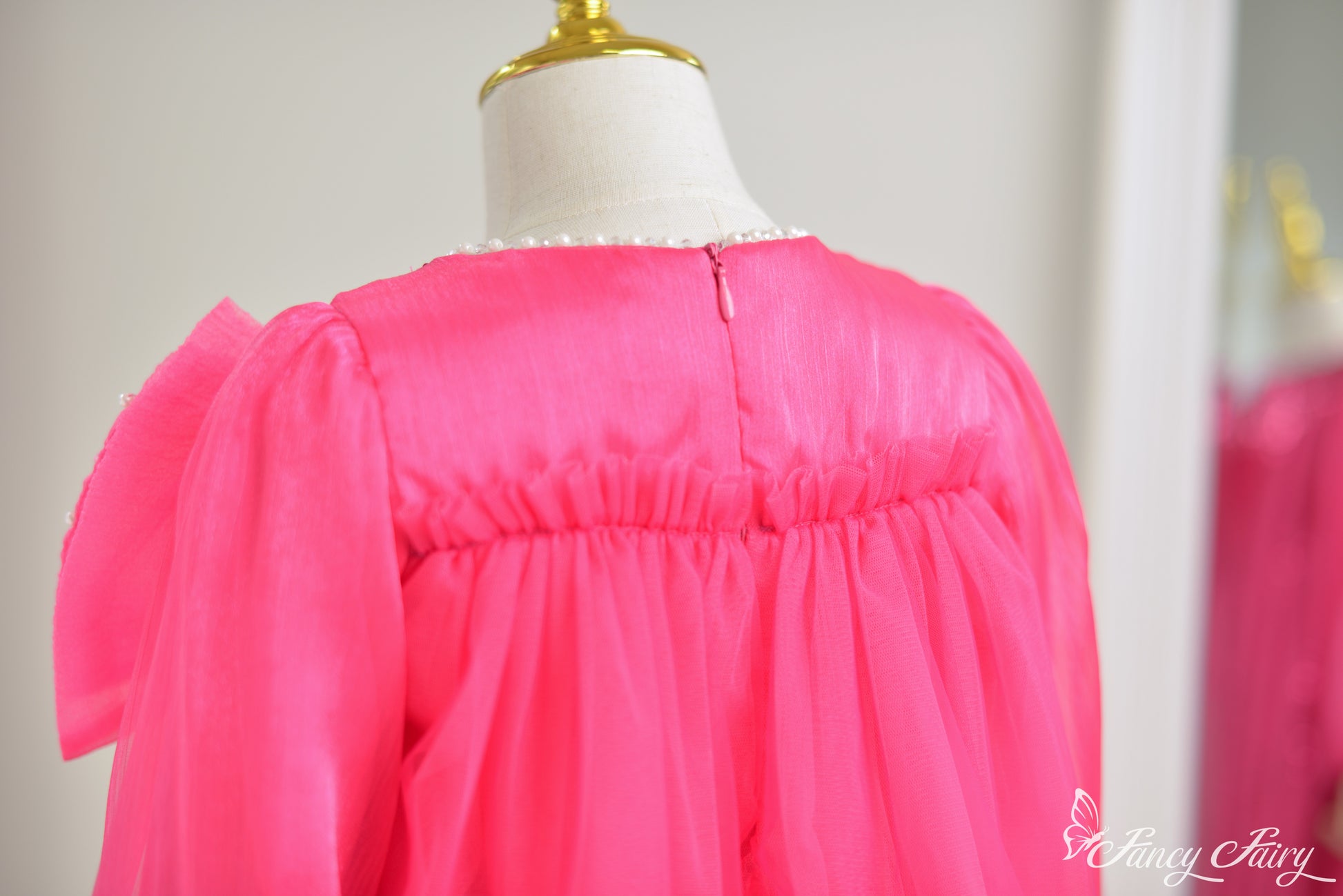 Back view of a bright pink dress showing zipper closure.