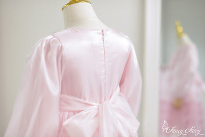 Back view of pink satin girl's dress with large bow detail.