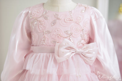 Close-up of floral embroidery with pearls and satin bow belt.
