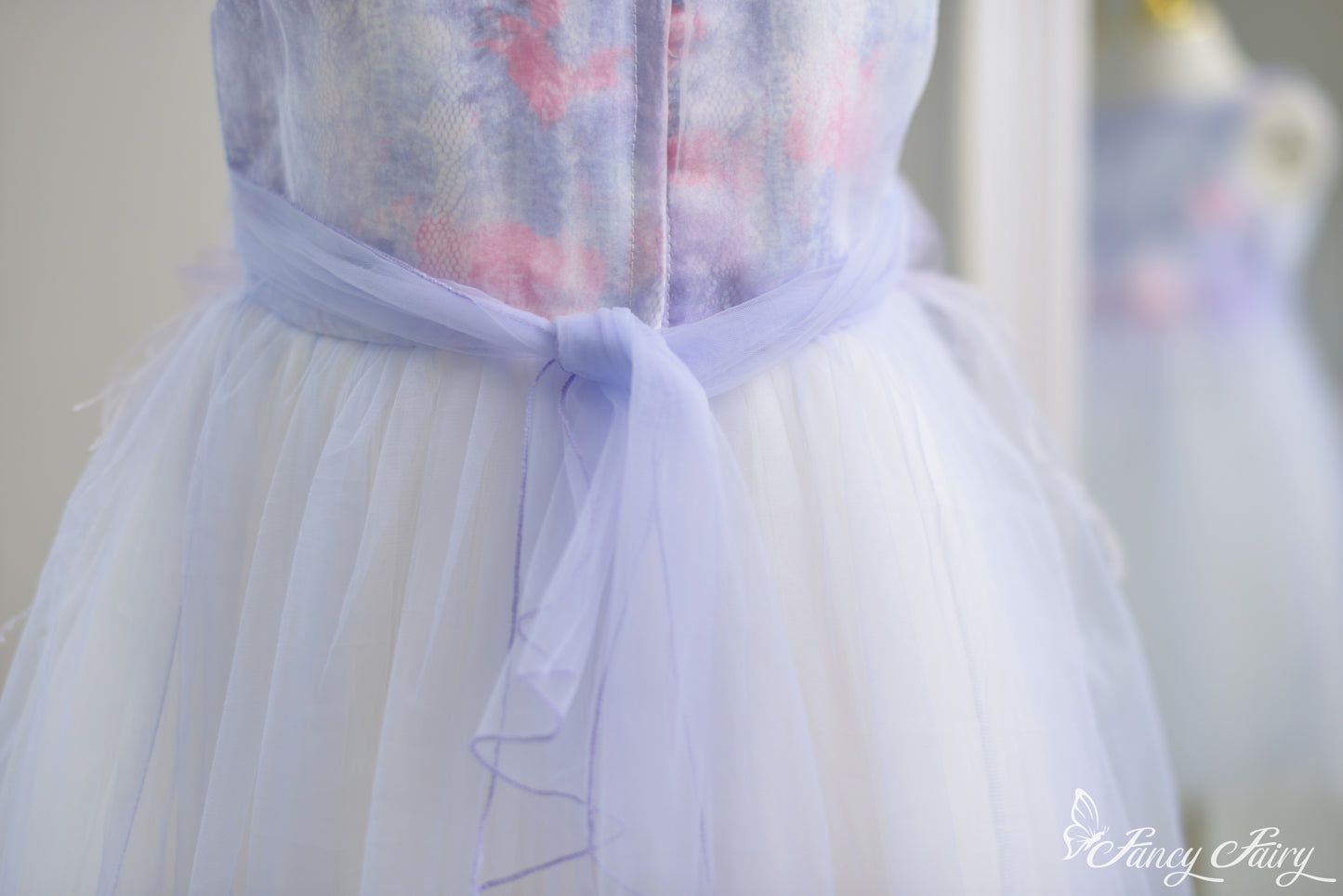 ack view showing sheer tulle bow, and zipper closure.