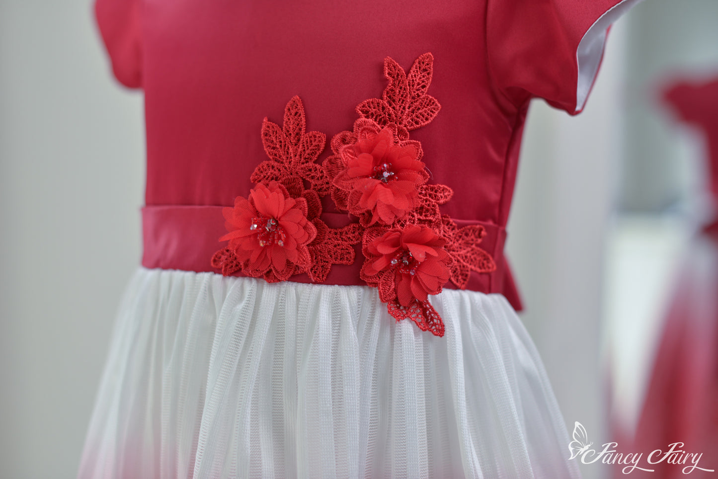 Angled view of the top half, highlighting red satin bodice and floral detail.