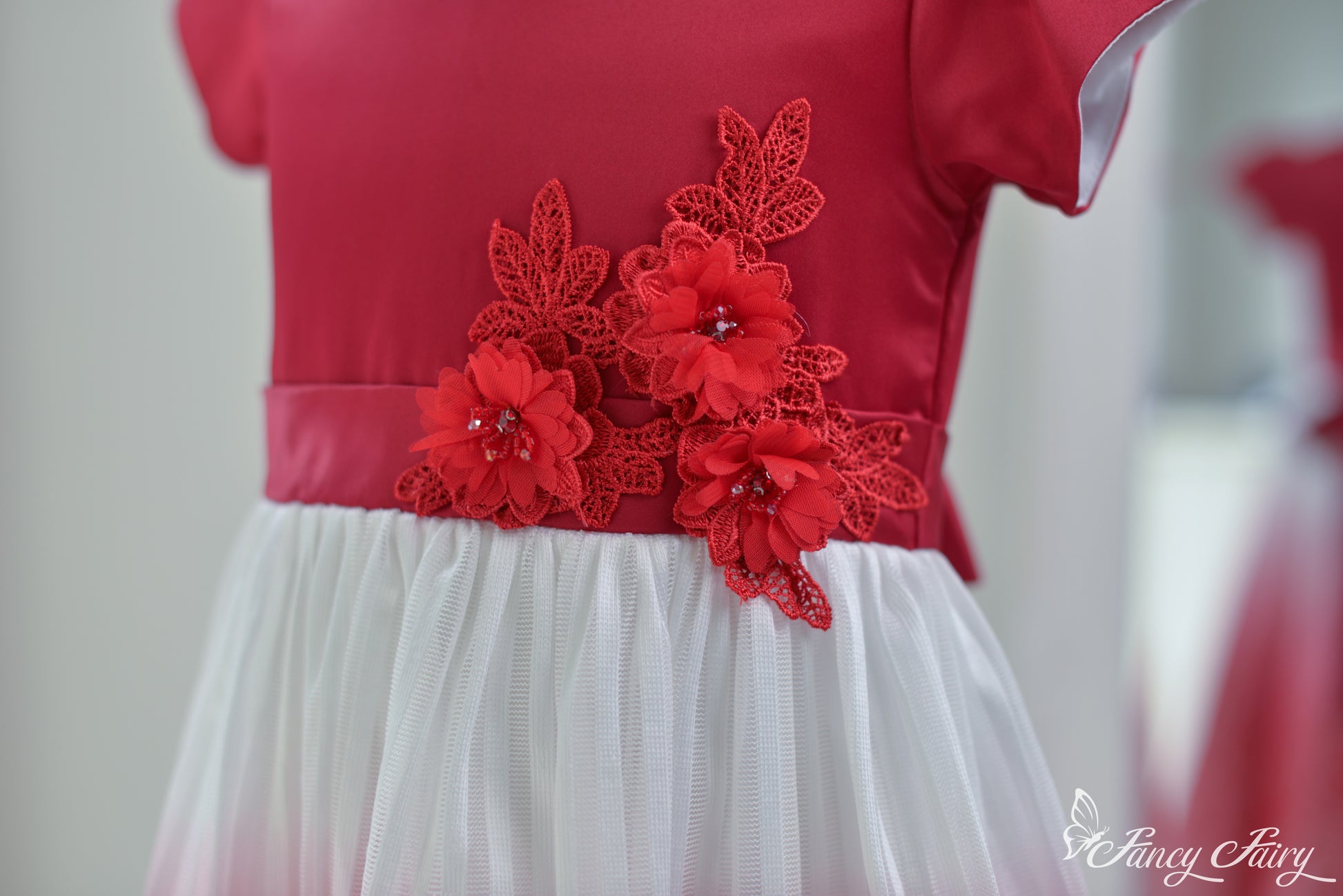 Angled view of the top half, highlighting red satin bodice and floral detail.
