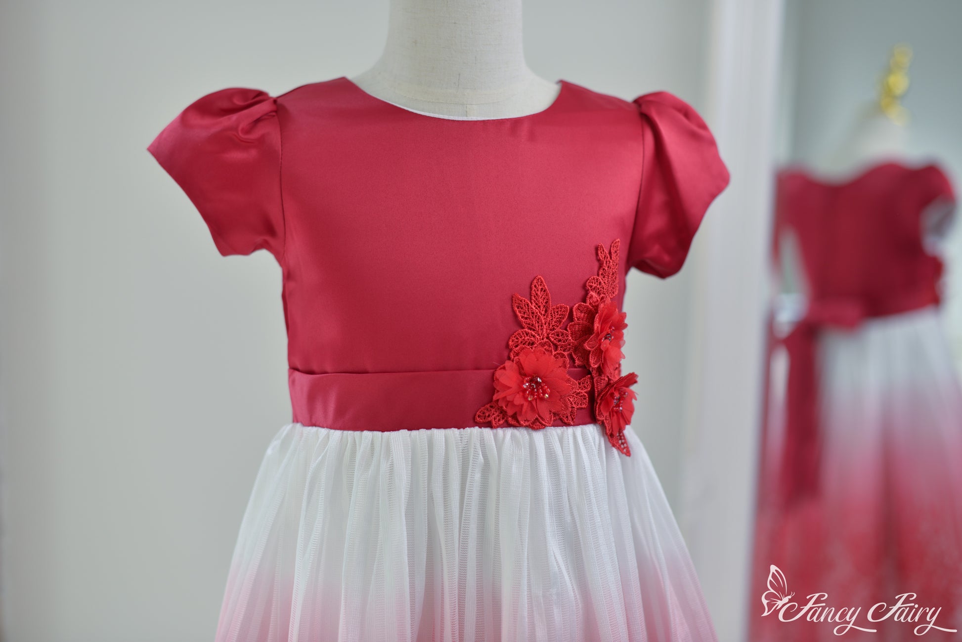 Angled view of the top half, highlighting red satin bodice and floral detail.