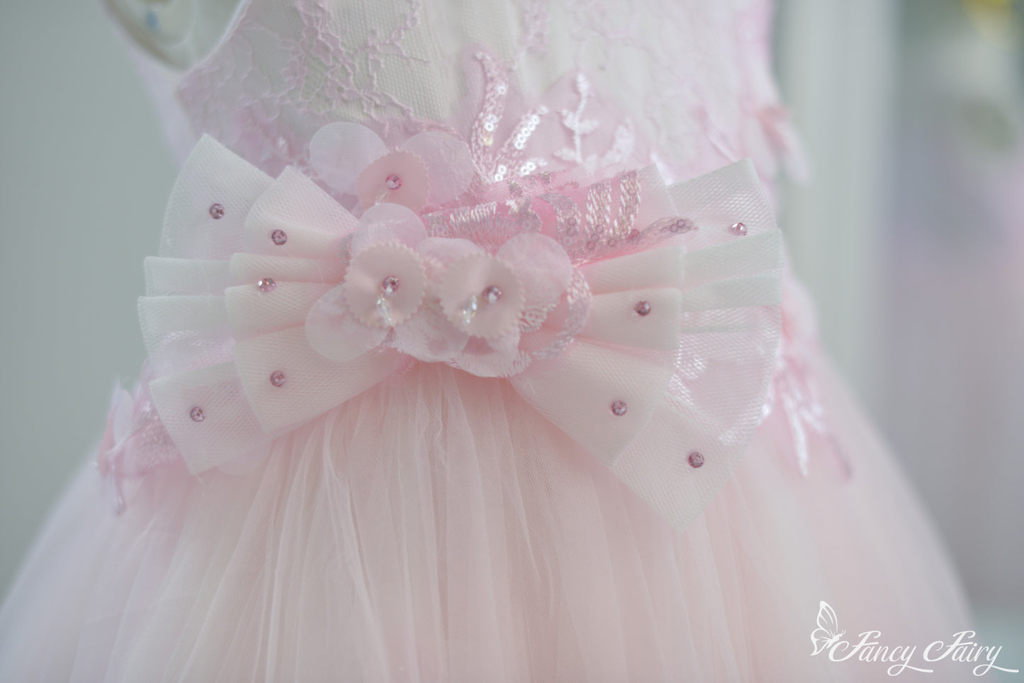 Close-up of sequin-pink flower bow detail with dotted tulle ribbon.