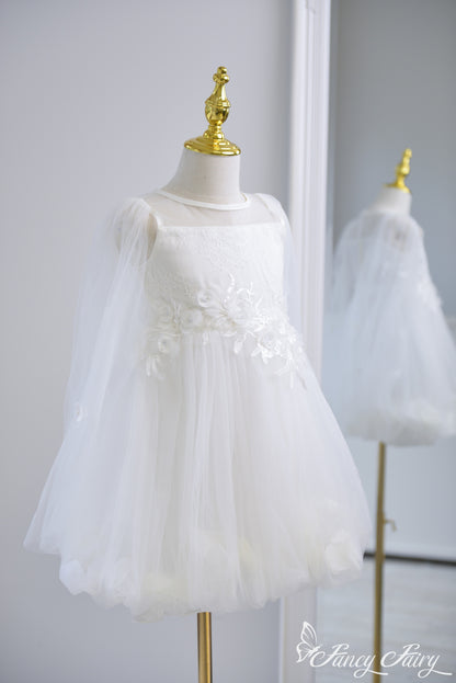 Side view of white girls' dress with floral embroidery, tulle sleeves, and petal-lined skirt
